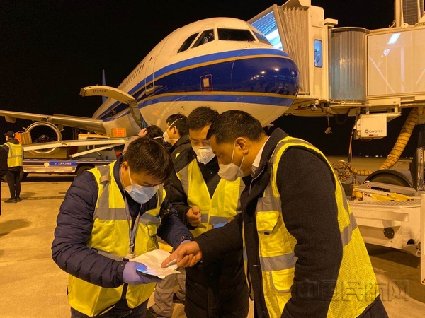 nEO_IMG_南航湖北分公司运行指挥部经理罗忠海(右一)同各保障单位值班人员在医疗包机保障现场