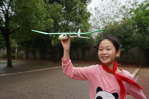 图为：何思娇试飞自己制作的飞机模型_副本.jpg