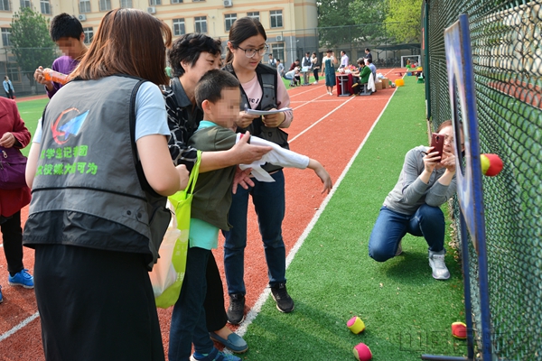 中国民航大学大学生记者团记者帮助孩子们做运动.jpg