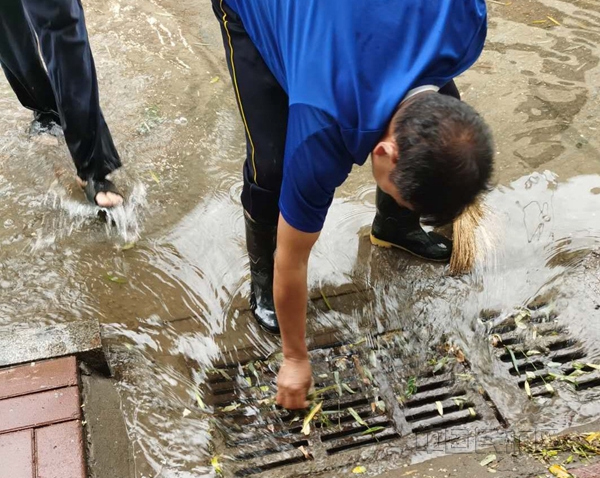 动力运行服务中心人员用手清理下水篦子上的垃圾 摄影：润涛_副本.jpg
