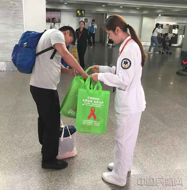 配图：三亚机场医护人员向旅客发放宣传资料.jpg