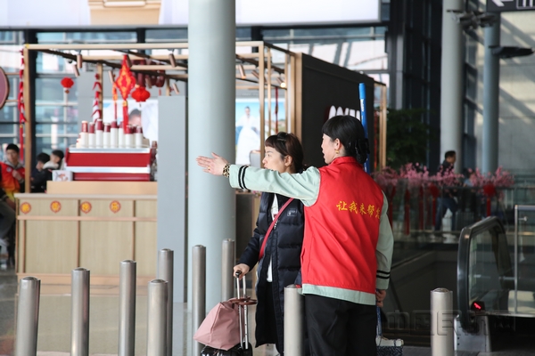 虹桥机场志愿者为旅客指引方向-邹丽洁摄