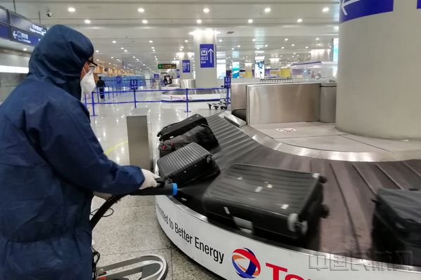 浦东机场工作人员为入境旅客托运行李消毒-钱擘摄.jpg
