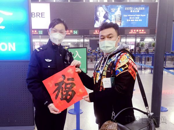 边检民警为出境旅客送福字-朱旭摄_副本.jpg 边检民警为出境旅客送福字-朱旭摄_副本.jpg