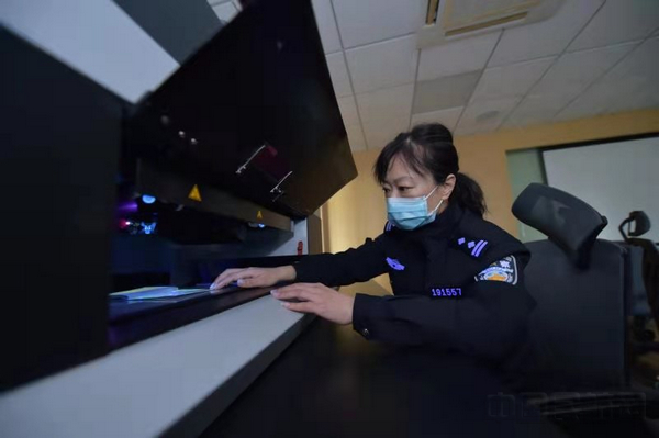 汪学超正在用专业仪器鉴定证件-魏文亨摄.jpg 汪学超正在用专业仪器鉴定证件-魏文亨摄.jpg