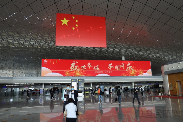 长春机场在航站楼公共区、候机隔离区内悬挂国旗与主题海报,增添国庆节氛围。作者:屈乐然1.jpg
