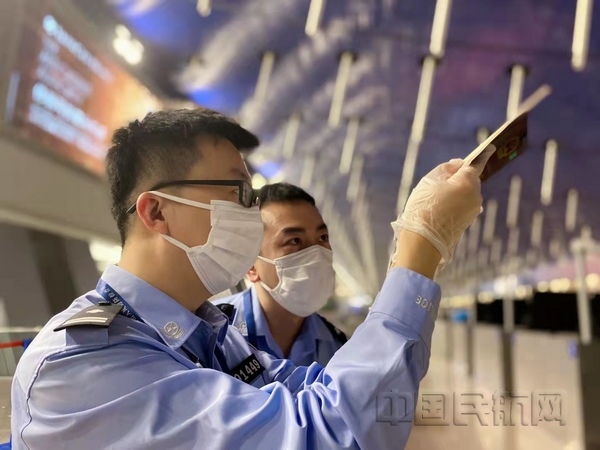 nEO_IMG_上海机场边检民警在执勤现场利用自然光辨识证件真伪-张波摄