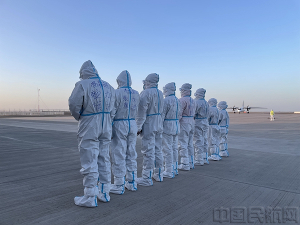 等待包机入位的额济纳机场员工,身着的防护服上写着“额旗加油”.jpg 等待包机入位的额济纳机场员工,身着的防护服上写着“额旗加油”.jpg