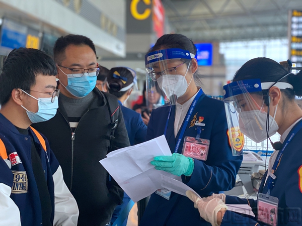 值机引导员正在为旅客讲解目的地机场疫情防控政策。.jpg