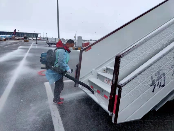 工作人员正在对客梯车上的积雪进行清扫。.jpg