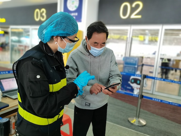 工作人员查验出港旅客粤康码和核酸检测结果.jpg 工作人员查验出港旅客粤康码和核酸检测结果.jpg