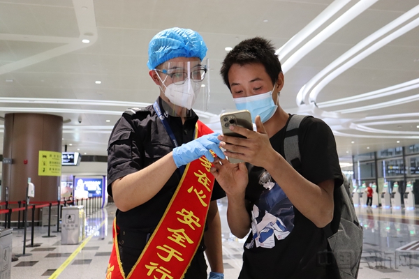水印 图:安检员帮助旅客查询航班信息1.jpg 水印 图:安检员帮助旅客查询航班信息1.jpg