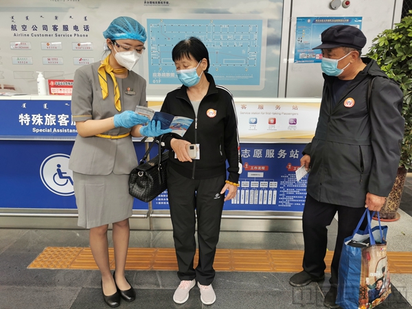 2首乘服务人员为首乘旅客讲解乘机指南上的注意事项.jpg 2首乘服务人员为首乘旅客讲解乘机指南上的注意事项.jpg