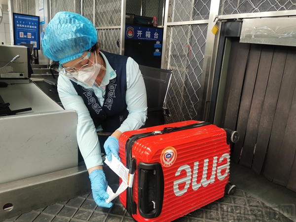 5值机人员为首乘旅客行李粘贴特殊标识.jpg 5值机人员为首乘旅客行李粘贴特殊标识.jpg
