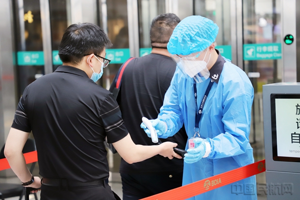 图说:安检员对进楼旅客进行百分百体温检测1.jpg 图说:安检员对进楼旅客进行百分百体温检测1.jpg