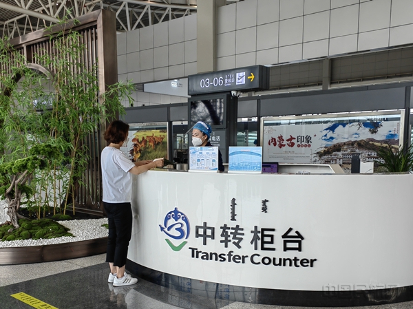 图:乘坐春秋航空航班的旅客在中转柜台办理手续 摄影:张佳1