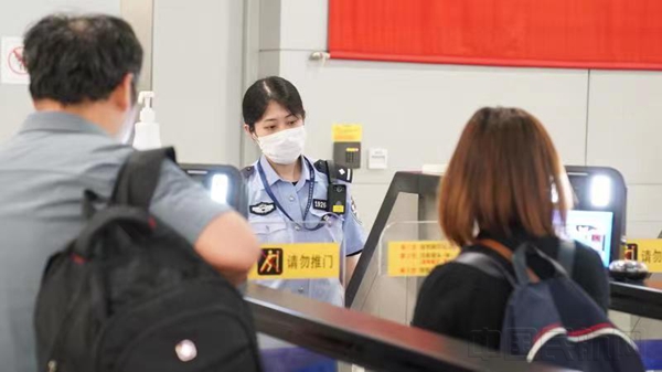 民警正在引导旅客使用快捷通道通关-石明明摄2