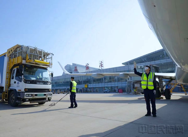 航机人员在指挥车辆靠近飞机(航空食品分公司田明辉拍摄)1