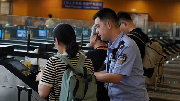 工作人员帮助旅客使用快捷通道-石明明摄1
