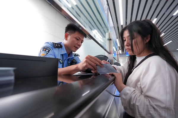 移民管理警察为符合条件的旅客办理240小时过境免签手续2(图: 黎锋俊)2