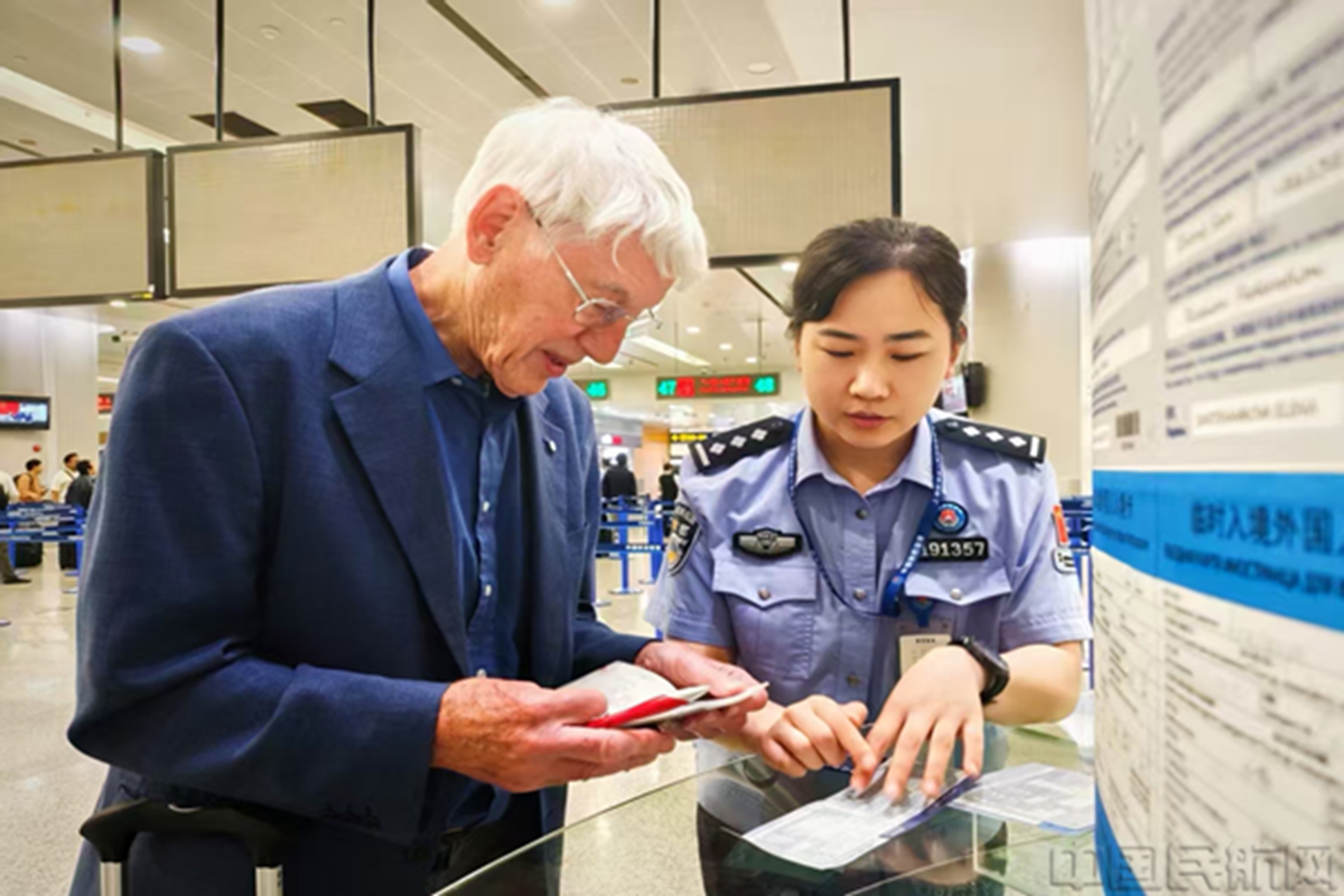 移民管理警察协助旅客完成通关-韩志一摄