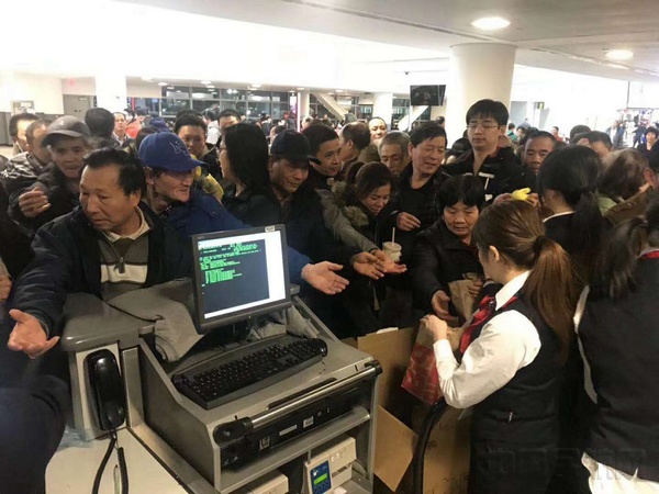 厦航纽约办事处工作人员向旅客发放餐食。.jpg 厦航纽约办事处工作人员向旅客发放餐食。.jpg