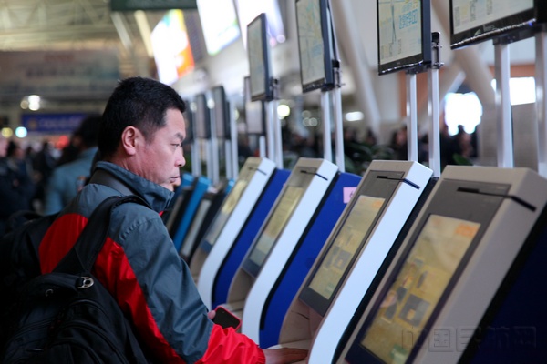 图2：春运首日，乘坐航班出行的旅客正在自助值机机器前办理手续.jpg