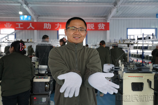 南航驻村队员刘峰欣喜的戴上了生产出来的“第一双手套”—安韵婷.jpg 南航驻村队员刘峰欣喜的戴上了生产出来的“第一双手套”—安韵婷.jpg