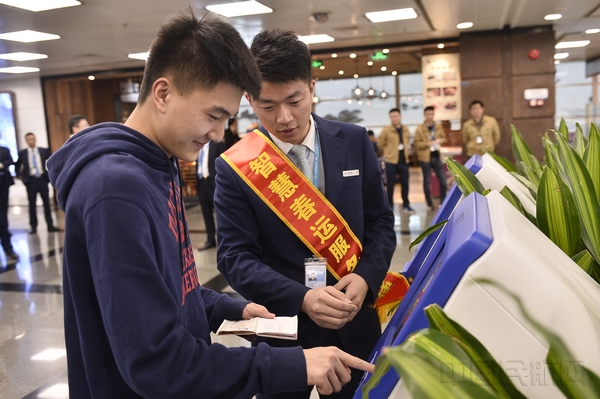 厦航地服工作人员向旅客演示国际（地区）航班CUSS自助值机服务。（贺晟 摄）.jpg