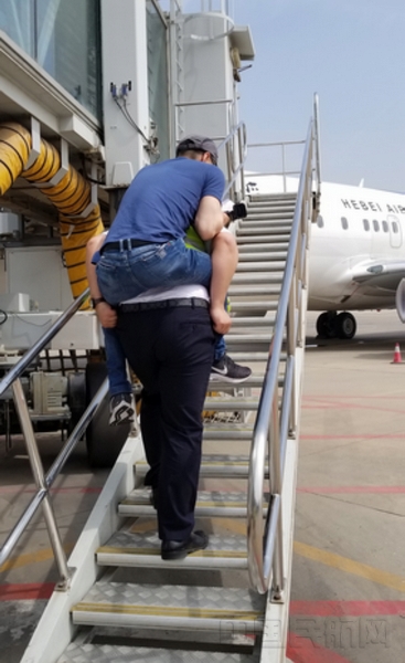 地服人员将特殊旅客---残疾人运动员背上航班.jpg 地服人员将特殊旅客---残疾人运动员背上航班.jpg