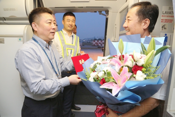 时晨 摄影 图为南航大连分公司党委书记迎接耿爱国60周岁生日当天航班,送上鲜花和返聘聘书.jpg 时晨 摄影 图为南航大连分公司党委书记迎接耿爱国60周岁生日当天航班,送上鲜花和返聘聘书.jpg