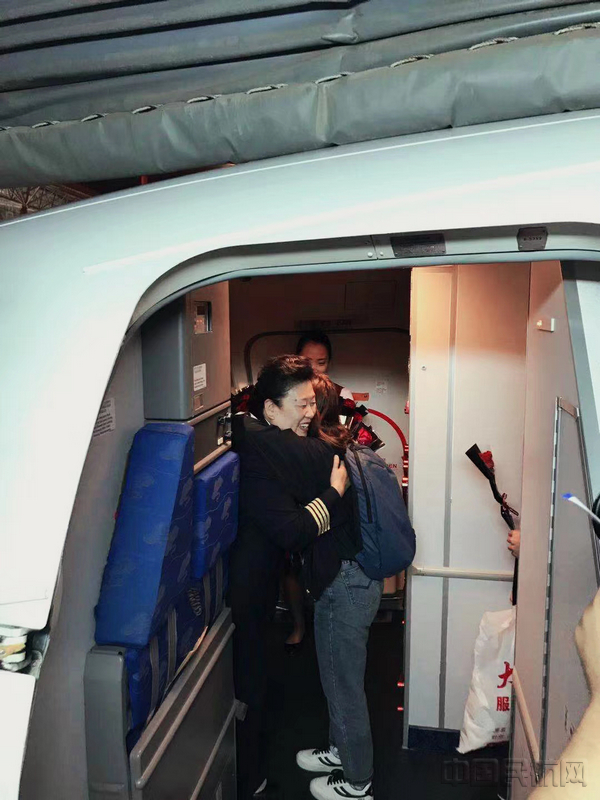 执飞完自己的最后一个航班后,王惠在舱门口和旅客话别.jpg