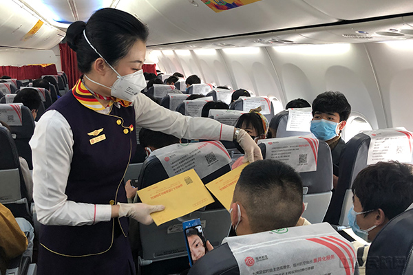 FU6510航班乘务员为旅客分发口罩 摄影李彦成1.jpg