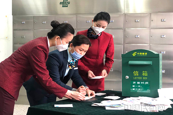 24、协助邮局工作人员盖邮戳。蒋燕拍摄