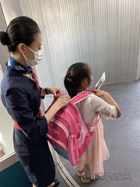 小旅客下机前,乘务员为她整理书包_副本.jpg 小旅客下机前,乘务员为她整理书包_副本.jpg