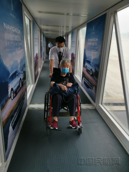 nEO_IMG_东航地服人员为百岁旅客申请轮椅服务,全程陪伴