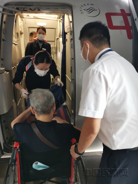 nEO_IMG_东航地服人员协助百岁旅客登机并与乘务组交接