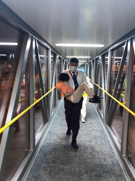 图2:范万春抱起旅客前往进行诊治.jpg 图2:范万春抱起旅客前往进行诊治.jpg