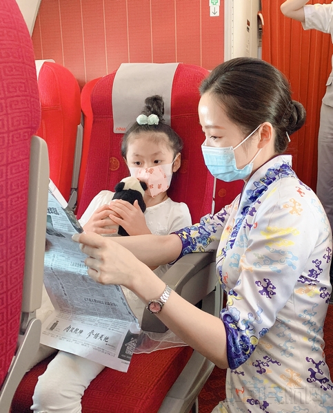 附图2:海南航空乘务员在餐饮服务后带领小旅客读报纸讲故事.jpg 附图2:海南航空乘务员在餐饮服务后带领小旅客读报纸讲故事.jpg