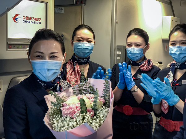 nEO_IMG_同飞的年轻乘务员们为李明华送上掌声和鲜花