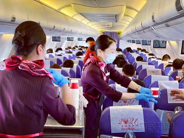 上航乘务员在首个正式开航大兴的航班上服务旅客-李金龙摄_副本.jpg 上航乘务员在首个正式开航大兴的航班上服务旅客-李金龙摄_副本.jpg