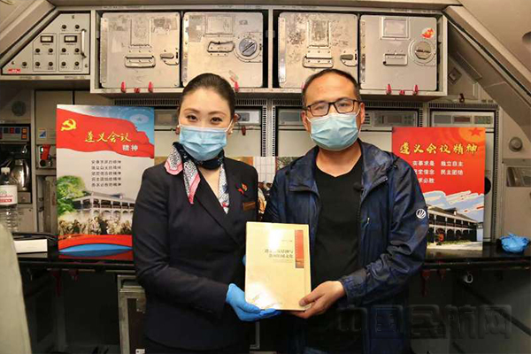 乘务组为旅客下发遵义历史书籍.jpg