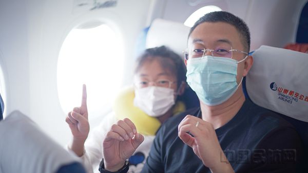 7月1日在山航SC4901济南-成都、SC8738青岛-长沙航班上，山航推出“空中党史课堂”活动，深受旅客欢迎。乘务员与旅客热情互动，旅客用手指比出“100”字样。谷巍 王佩阳 摄_副本.jpg