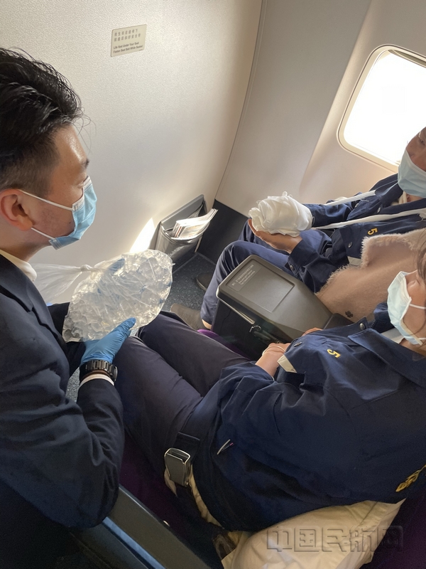 nEO_IMG_航班机组按照“东航空中医疗专家”的专业指导在航程中保障伤员-东航供图
