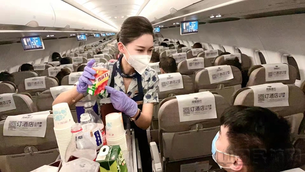 乘务员为旅客推荐新加入航班饮品的上海老字号怀旧饮料-东航客舱供图2