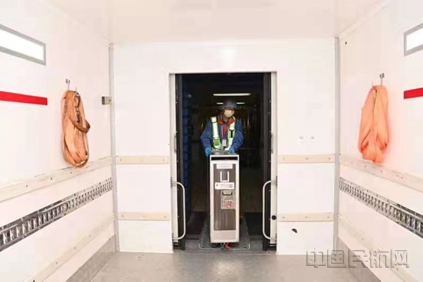 季陆兴将装配好的餐食推进配餐车货箱-东航供图.jpg