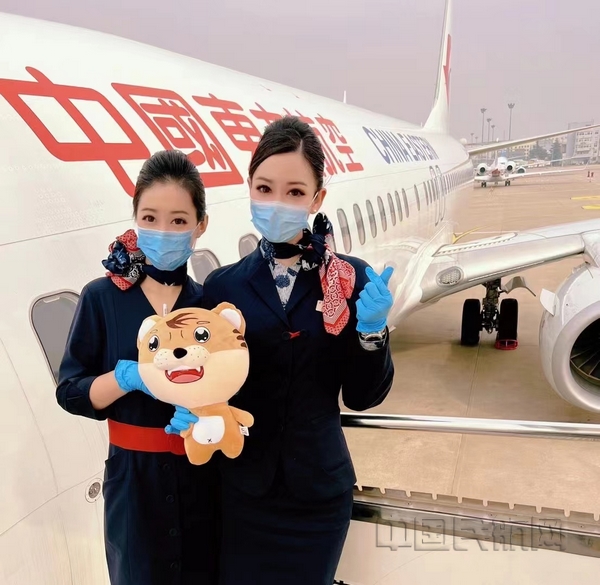 nEO_IMG_东航客舱乘务二部乘务员郭苗、吴艳手持虎年公仔迎接旅客登机