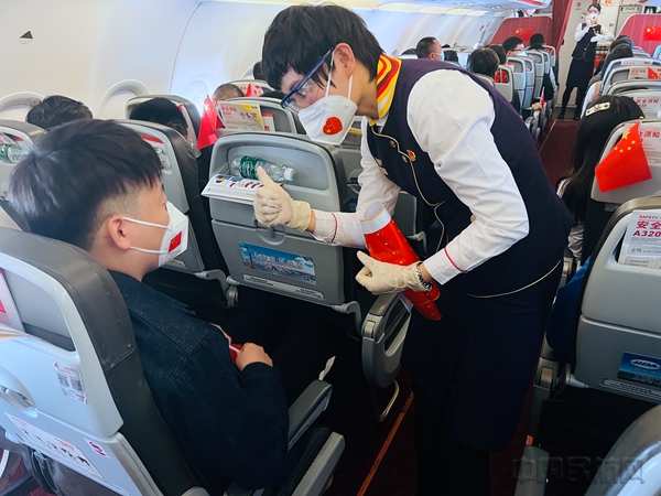 图一 乘务员为旅客发放国旗3.jpg 图一 乘务员为旅客发放国旗3.jpg