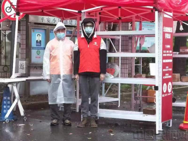 束强生（左）带领志愿者团队成员冒雨值守小区-东航供图.jpg