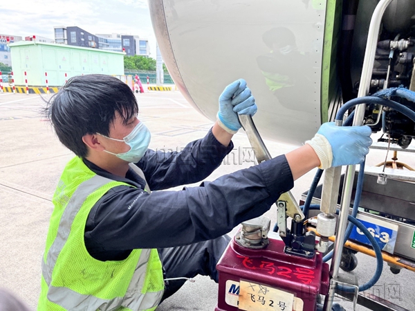 为发动机加注完滑油，平时可以一气呵成，而高温天气按压三四下后就汗流浃背-东航供图_副本.jpg